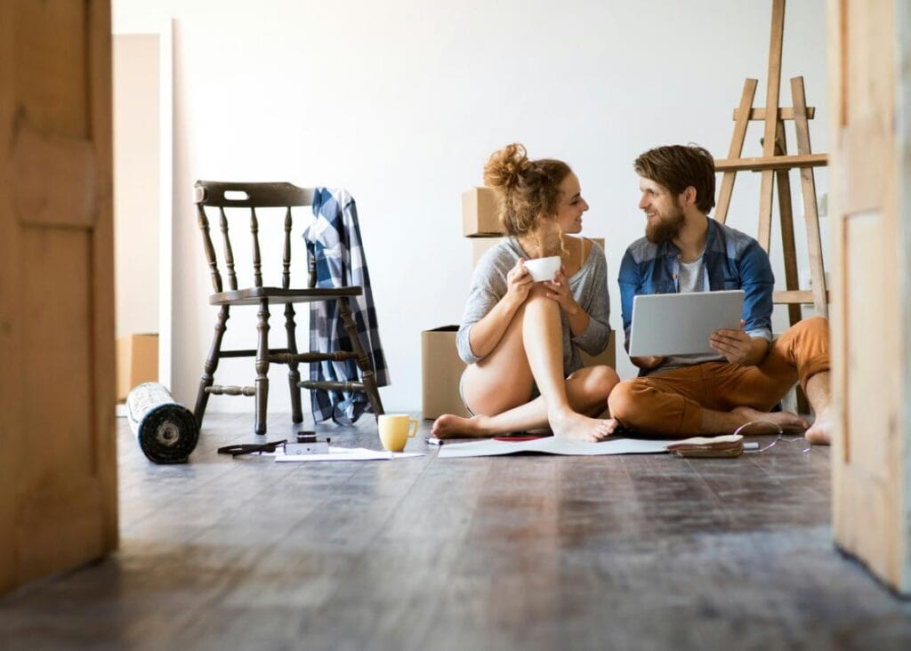 couple sitting in floor discussing home improvement plans