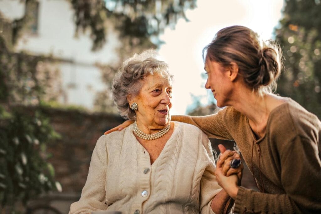 woman and her elderly mother sitting in a garden