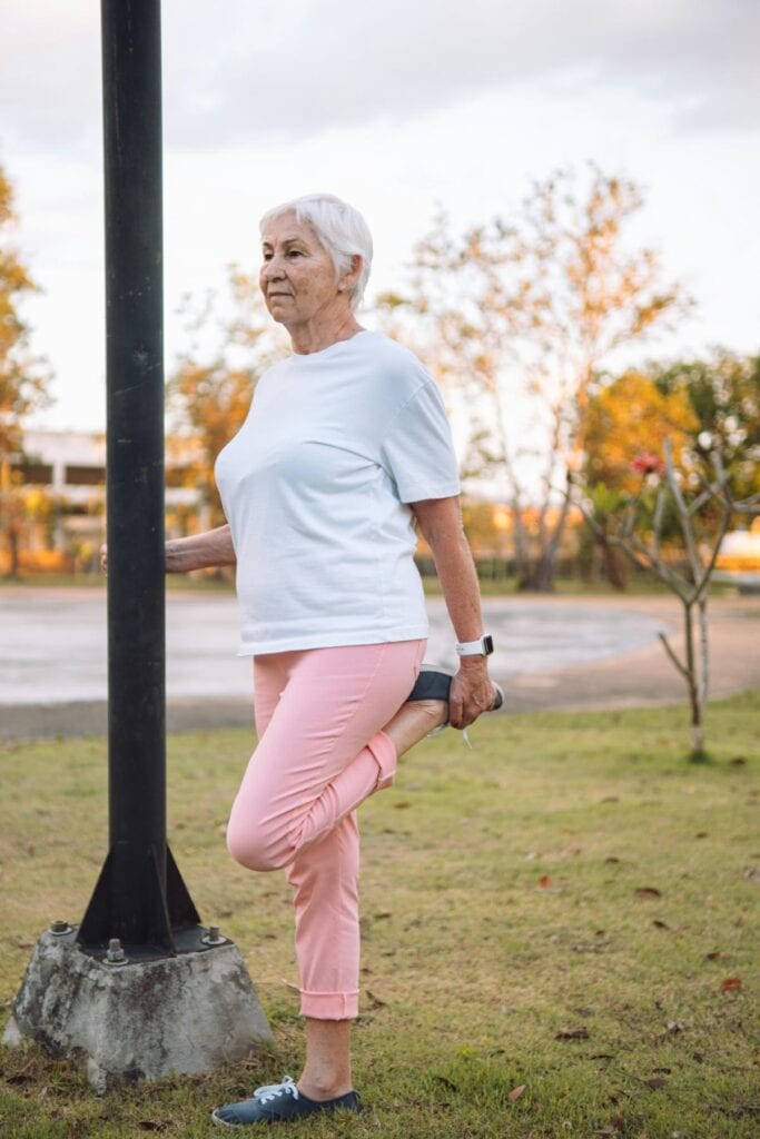senior woman stretching outdoors