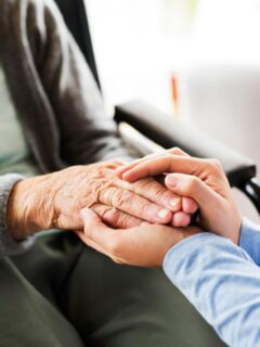 person holding hands of elderly woman