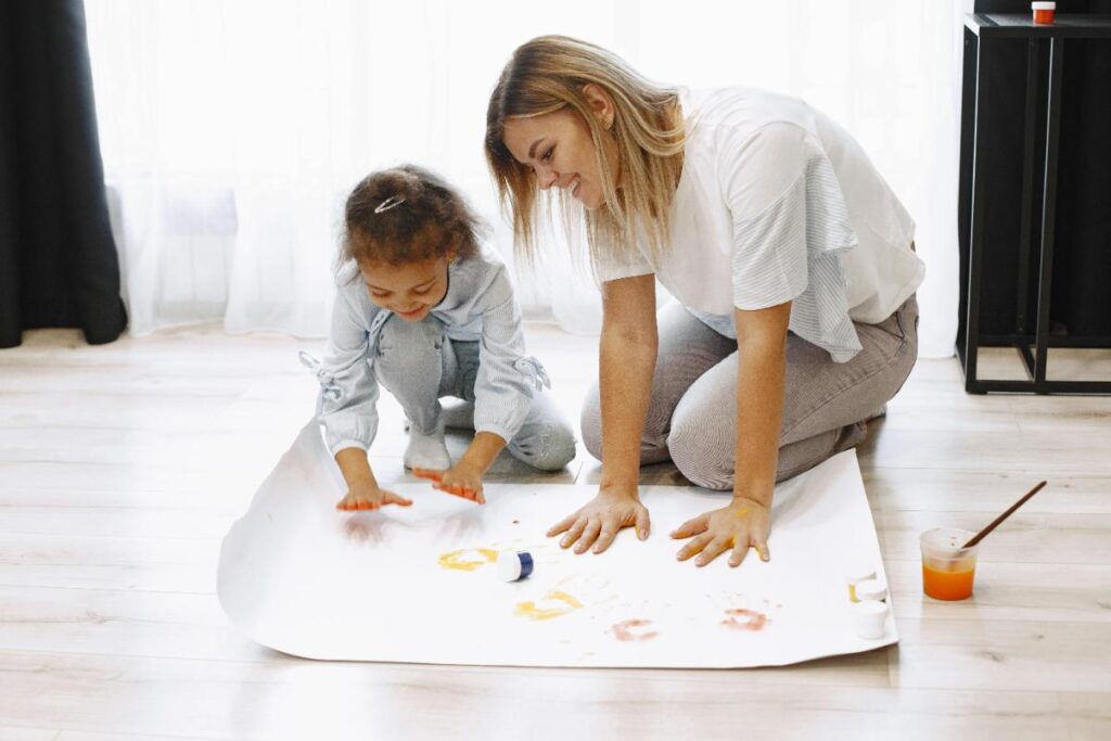 mom and daughter making handprint art