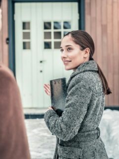 a realtor inviting a client to go inside a home for sale