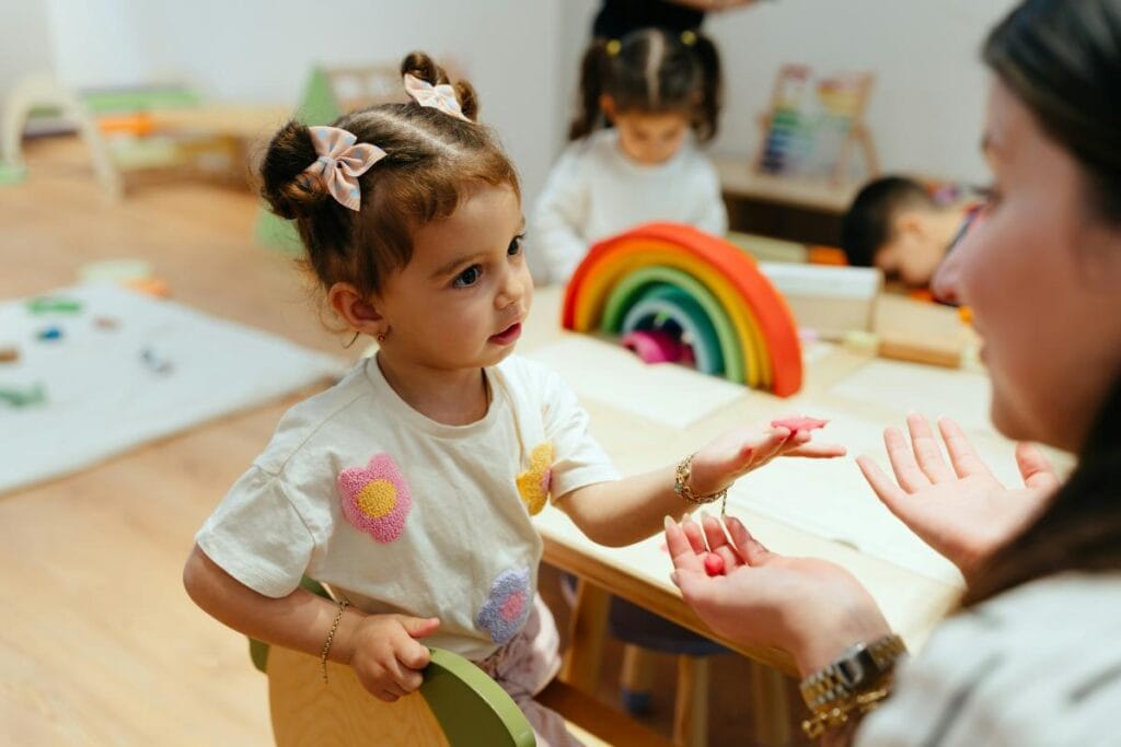 toddler girl talking to daycare teacher