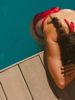 woman in water leaning on deck
