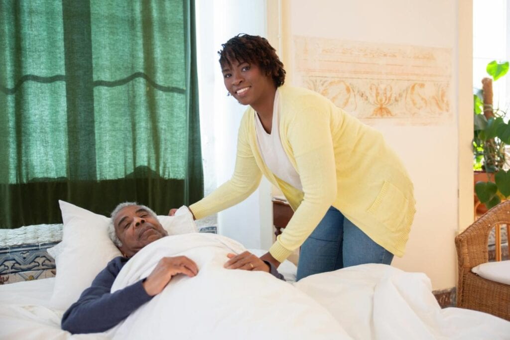woman tending to an elderly man at his bedside