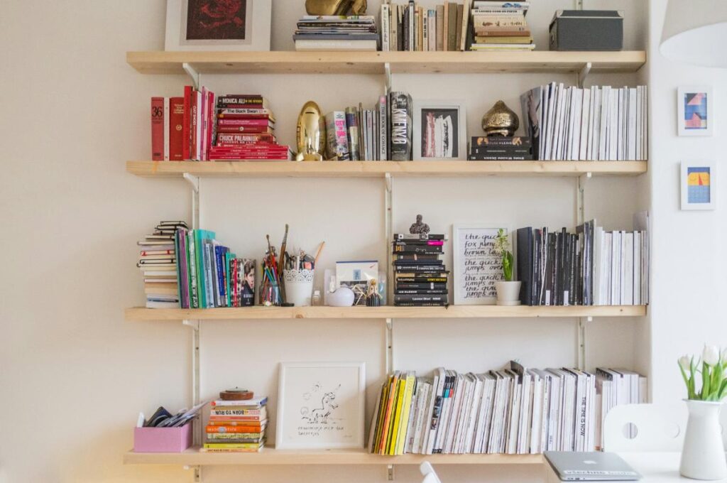 Organized wall shelves filled with books, magazines, and storage items, showcasing a tidy home environment that supports mental clarity and focus.
