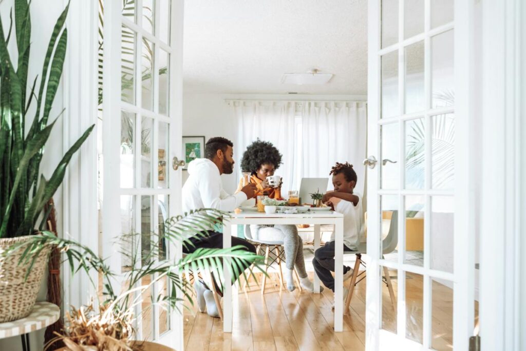 family eating breakfast together in bright airy kitchen