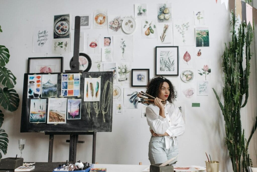 female artist in front of a wall of artwork