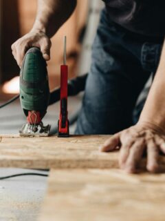 man cutting plywood for home repair project
