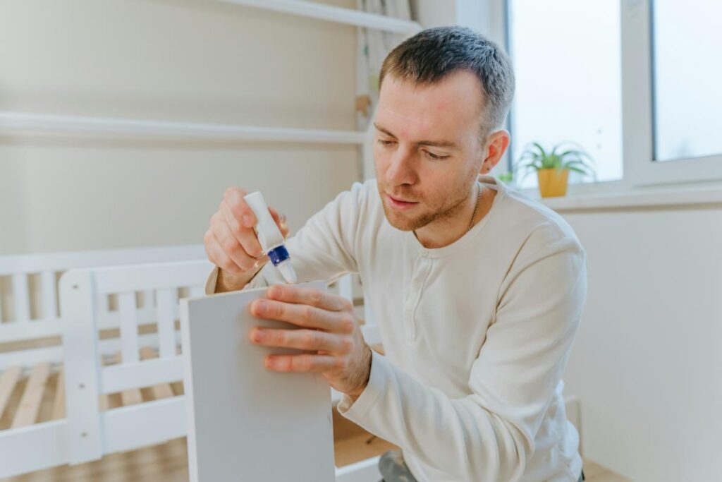 man using glue during furniture assembly