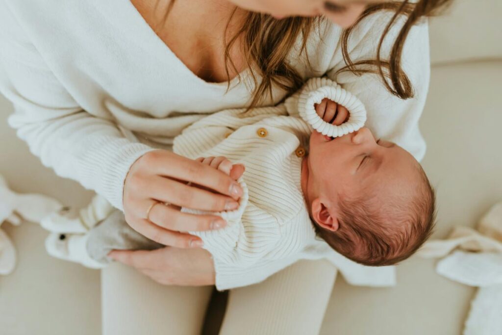Parent holding a newborn baby while soothing them, illustrating everyday caregiving and nurturing routines.