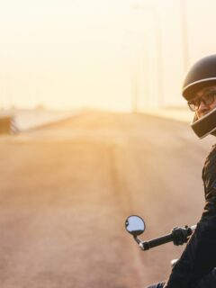 man on parked motorcycle looking back at camera