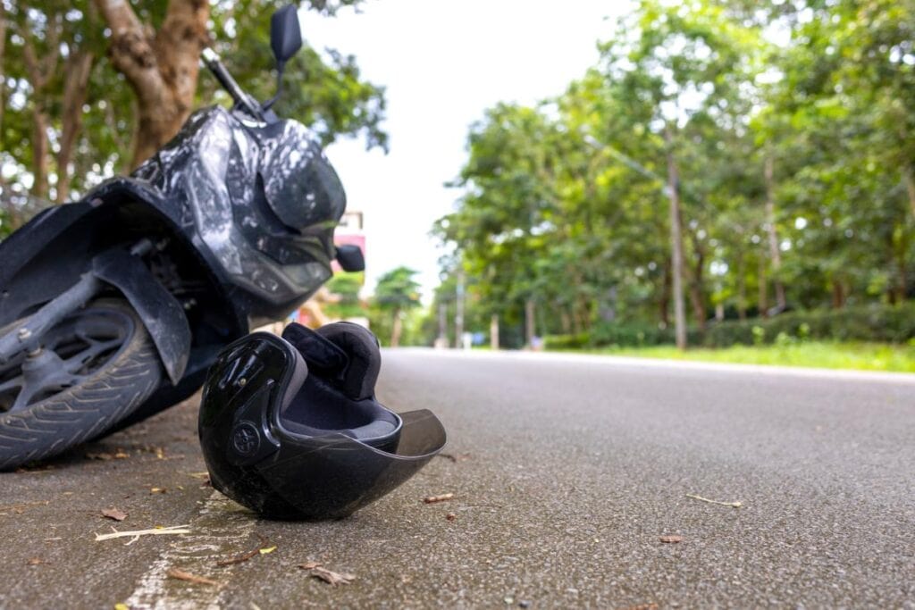 helmet and overturned motorcycle beside road