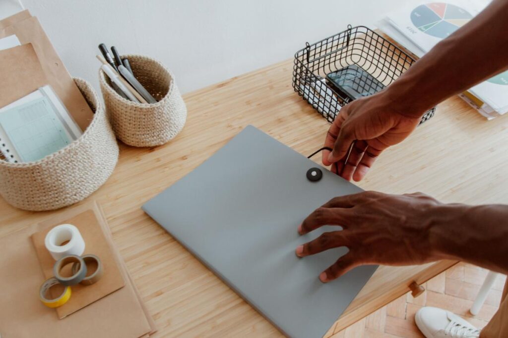 Person organizing documents on a clutter-free desk, demonstrating simple habits that help maintain structure, efficiency, and peace of mind.