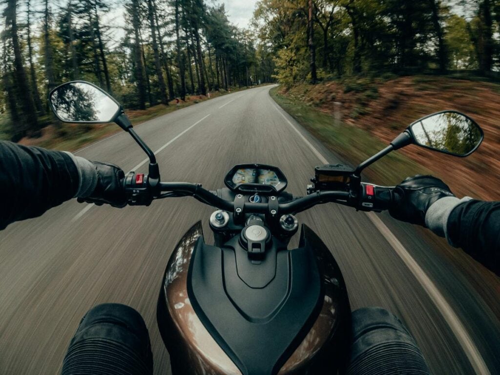 person with two hands on motorcycle handlebar