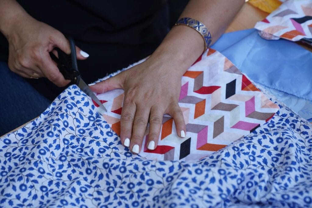 woman cutting quilting pieces with fabric scissors