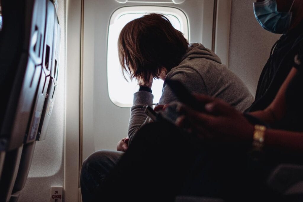 woman looking out airplane window