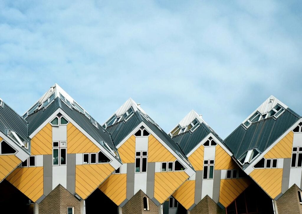Innovative cube-shaped residential buildings with distinctive geometric architecture, colorful facades, and metal roofing.