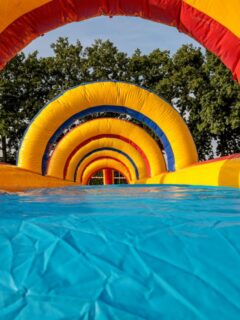 Inflatable water slide with colorful arches and a long sliding lane, showcasing a durable outdoor attraction for family events and summer fun.