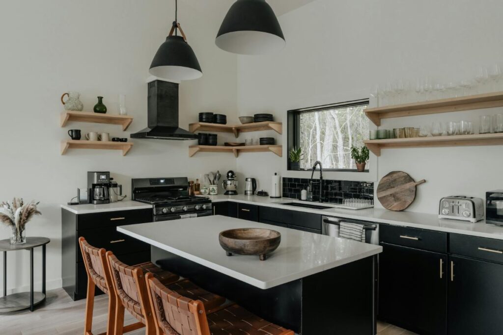 Contemporary kitchen featuring a black range hood, spacious island, and stylish open shelving.