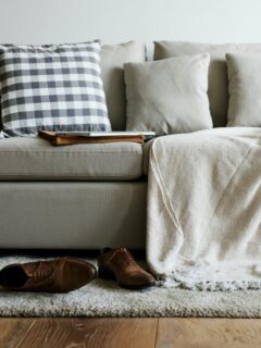 gray couch with pillows and a blanket