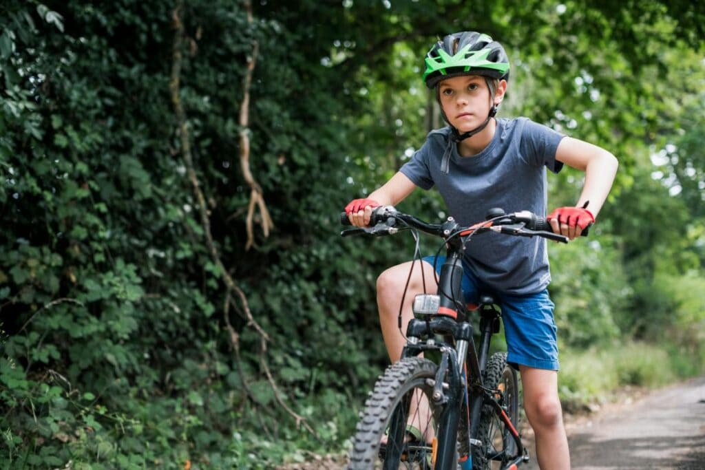 little boy on trail bike green helmet