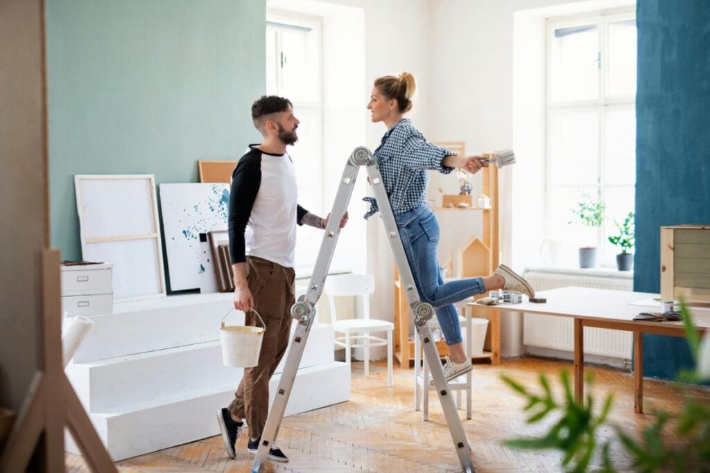 couple on ladder home improvements concept