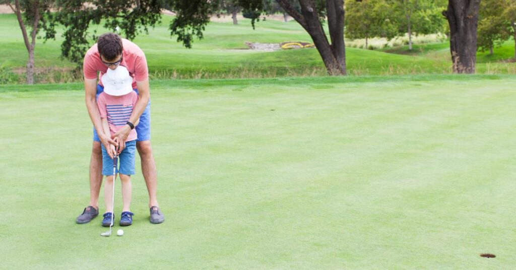 father teaching son how to golf