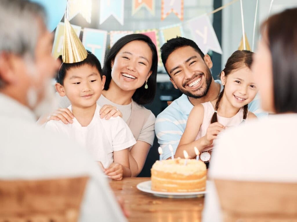 smiling family at table with birthday cake