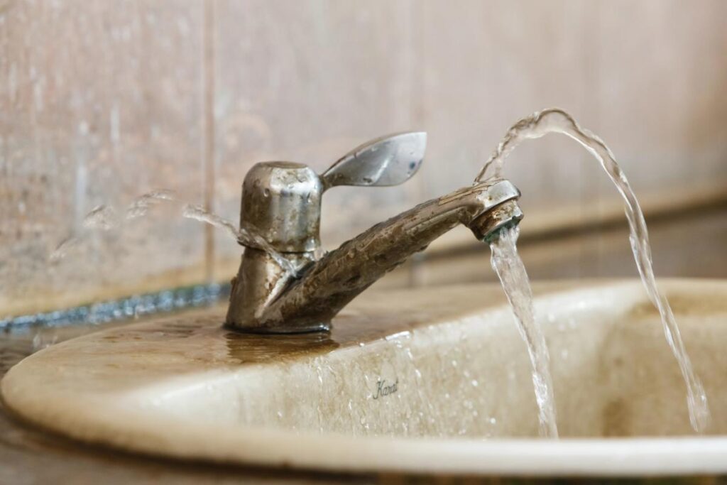 Leaking bathroom faucet wasting water and highlighting the need for plumbing repairs.