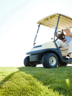 older man on golf cart on sunny day