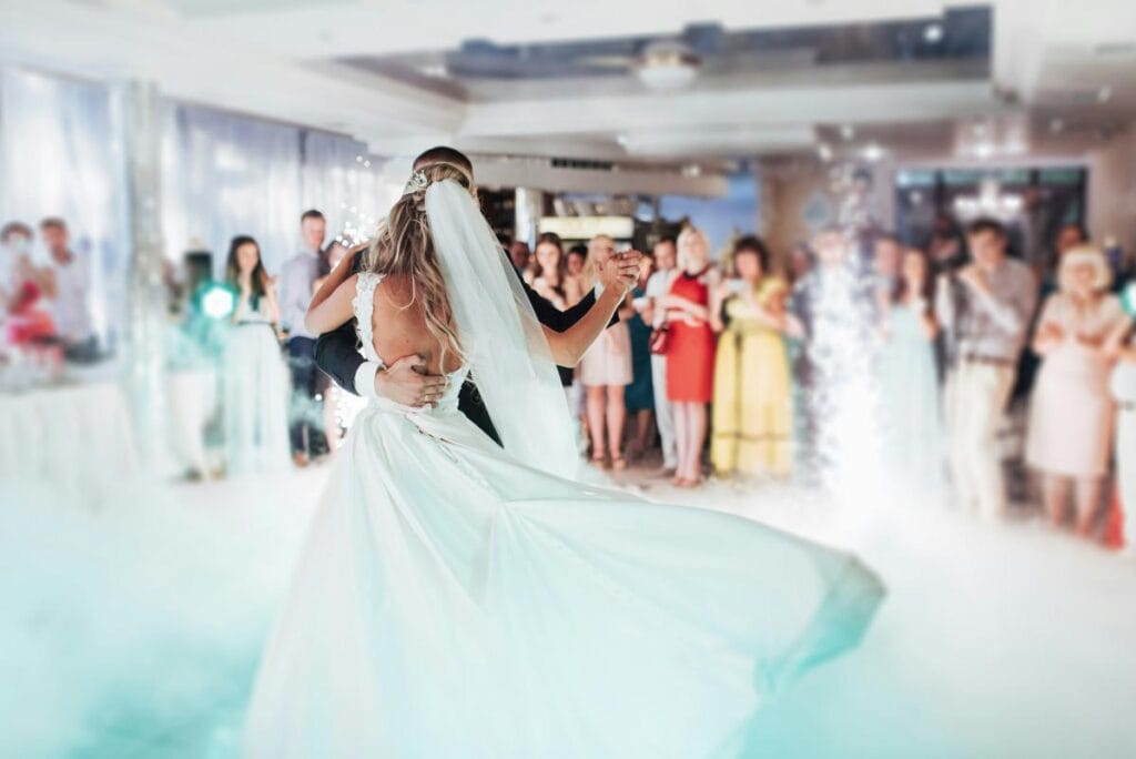 people watching bride and groom dance at wedding reception
