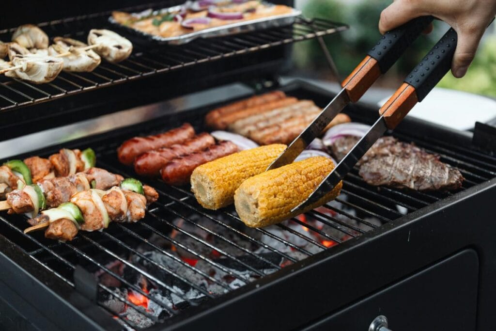 cooking meat and veggies on charcoal grill