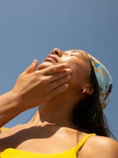woman applying sunscreen outdoors