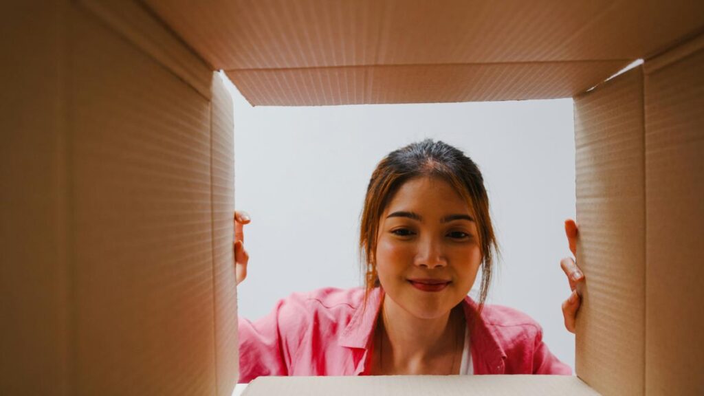 Person looking inside a cardboard box for creative home organization ideas.