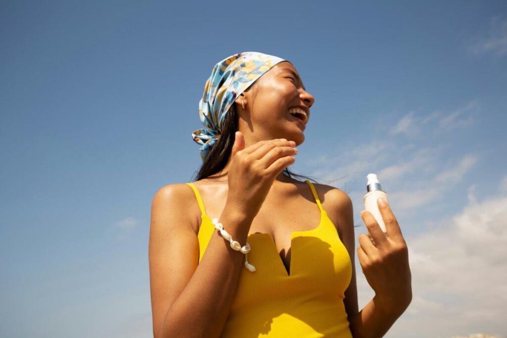 woman outdoors with bottle of sunscreen