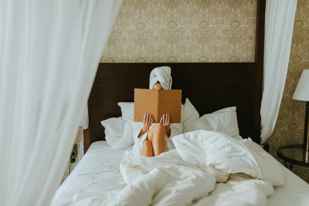 woman reading book in luxury bed