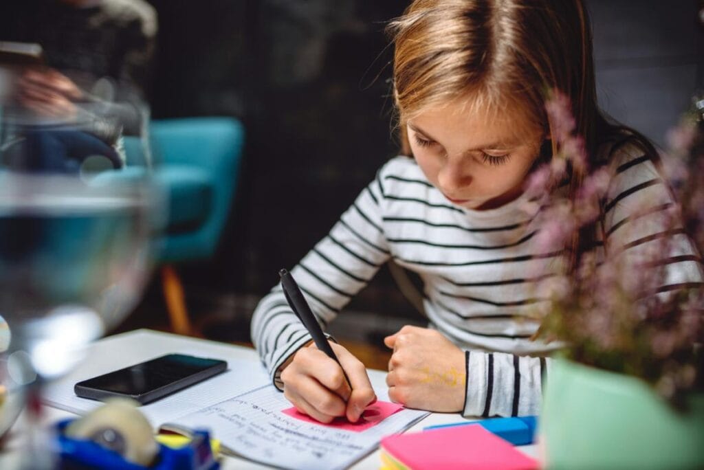 girl writing in journal and adding sticky notes