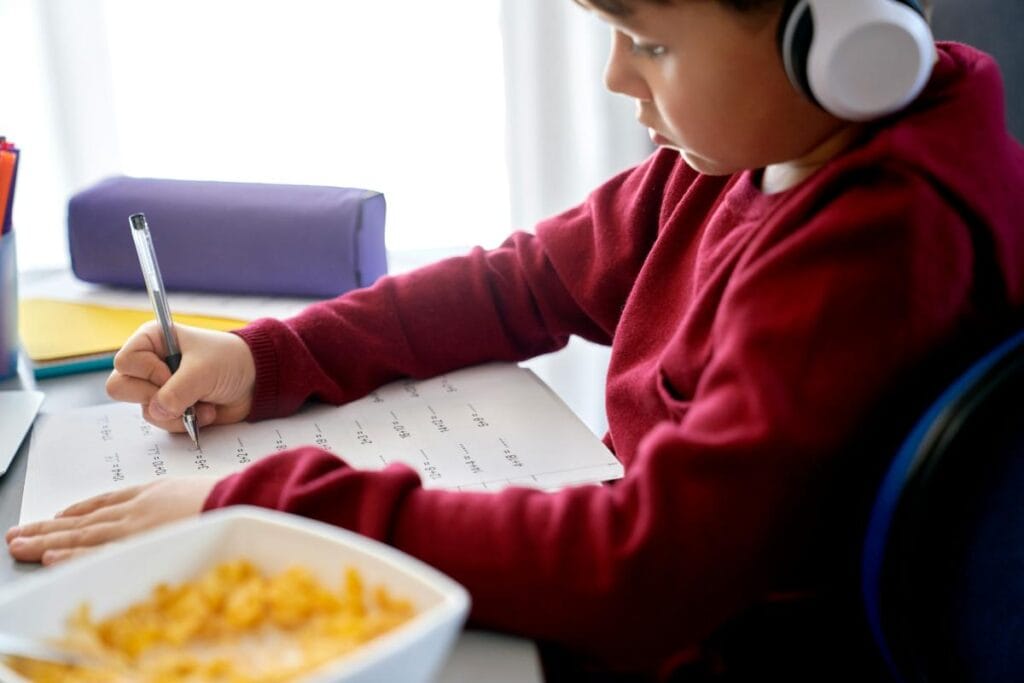 boy having a snack while working on math homework