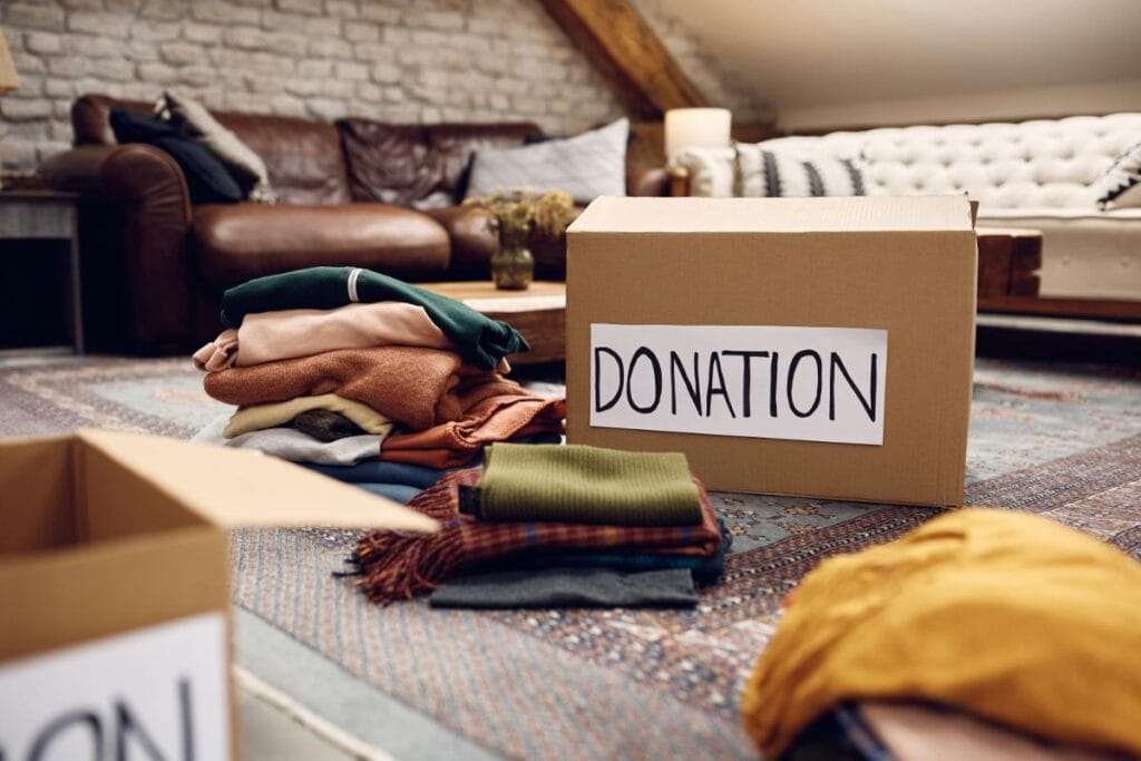 Donation box and folded clothes prepared during a home cleanout.