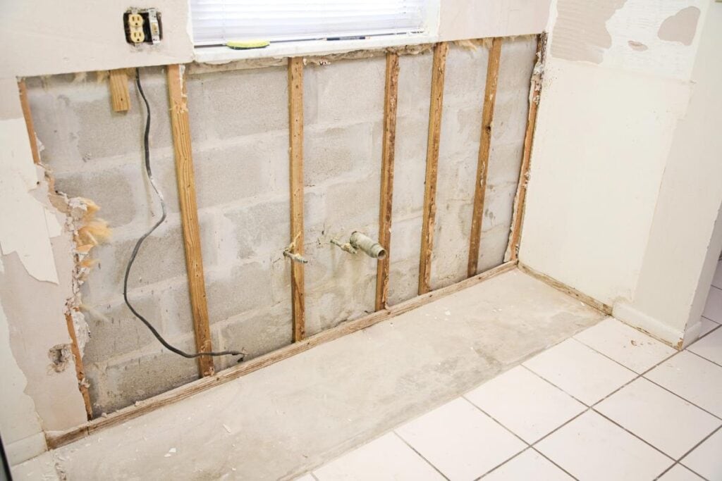 Wall opened to repair hidden water damage after a plumbing leak.