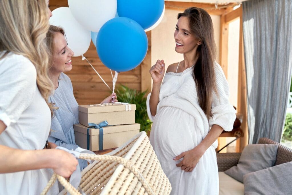 Friends celebrating a baby shower with gifts for the expectant mother.