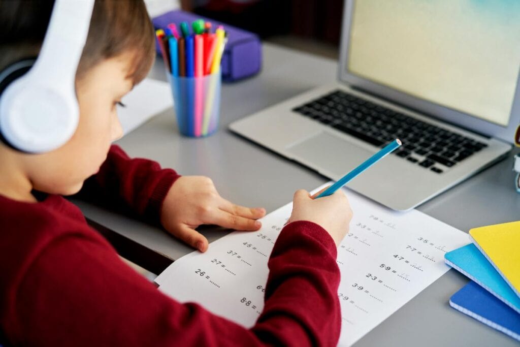 boy wearing headphones working on multiplication problems