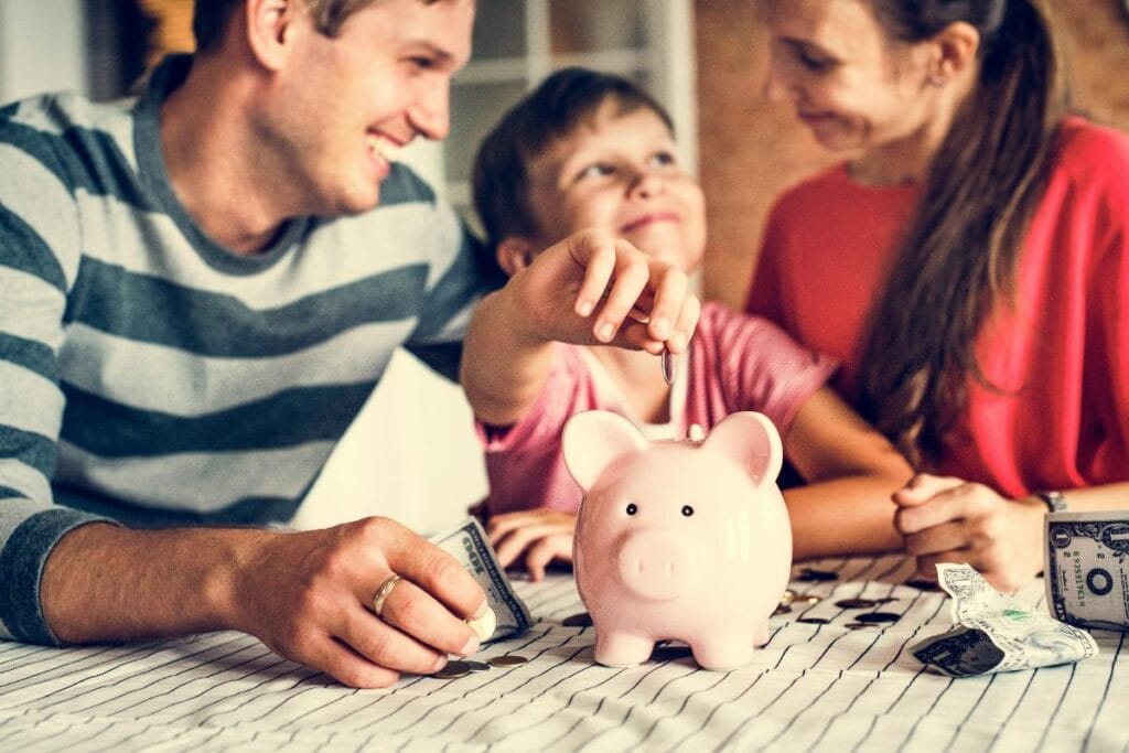 Family saving money together with a piggy bank.
