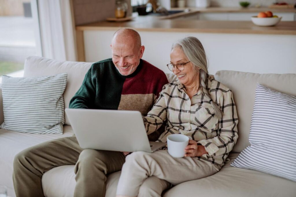 Older couple reviewing retirement finances on a laptop.
