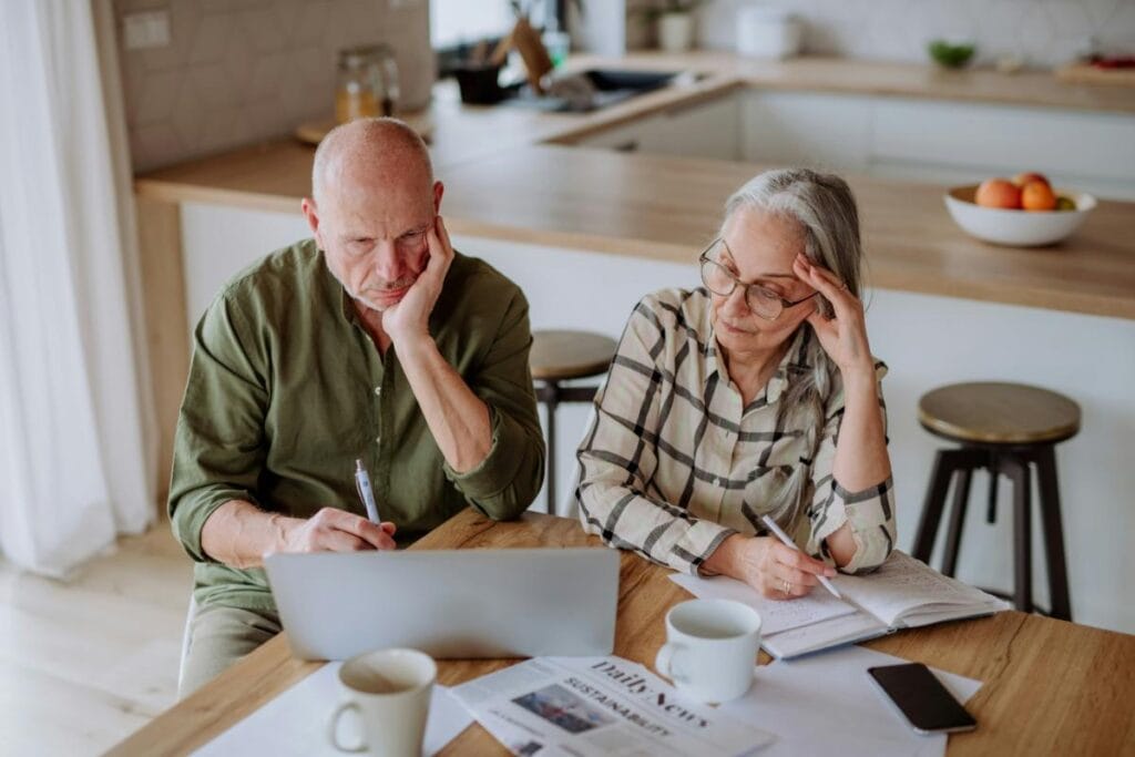 Senior couple planning their retirement budget at home.