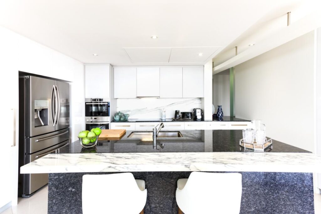 Contemporary kitchen featuring stone countertops and island.