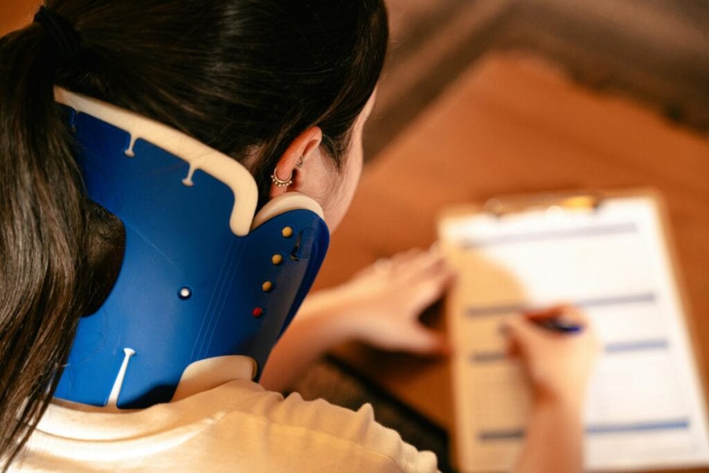 woman in neck brace completing form