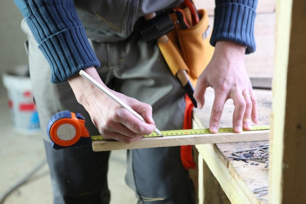 Builder measuring and marking a board during home construction