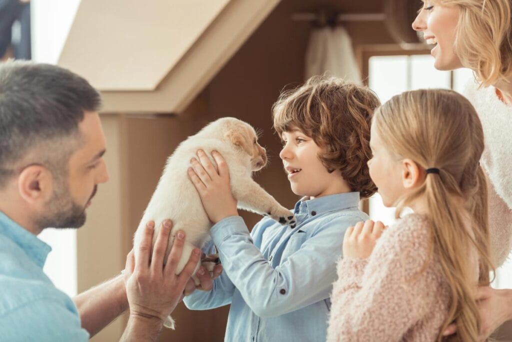 dad giving puppy to kids and wife